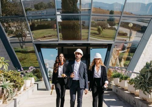 Business professionals walking outside modern glass conference center.